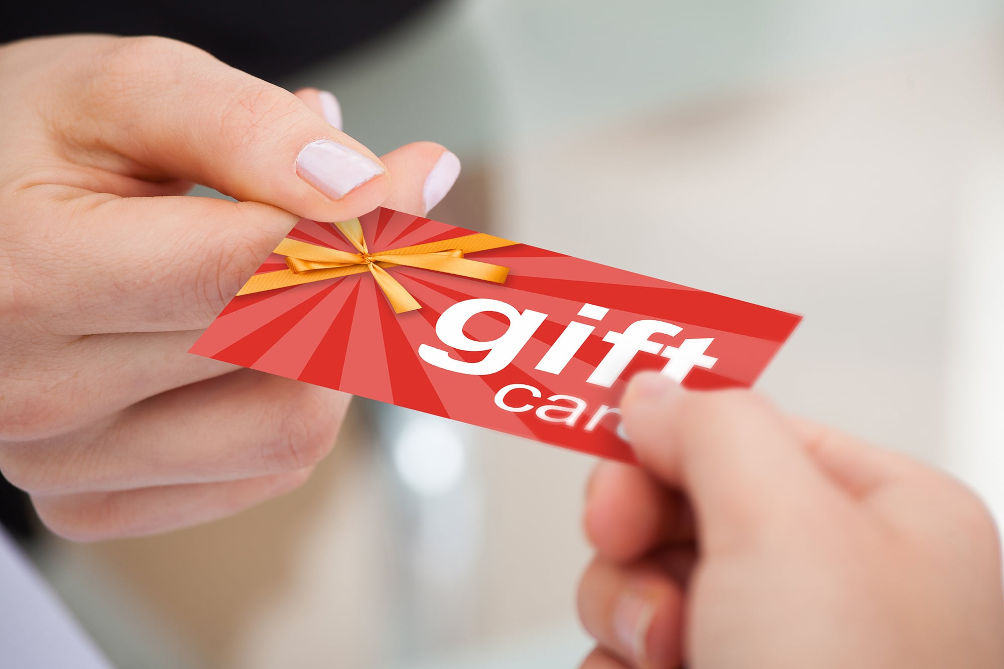 Person Hand Giving Gift Card To Another Person