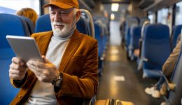 Senior man reading on tablet in train