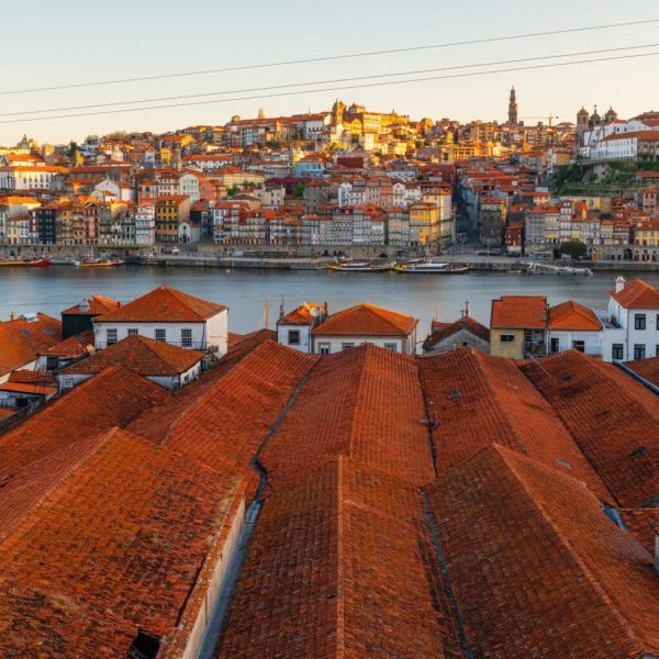 Porto, Portugal old town on the Douro River with orange rooftops of Vila Nova de Gaia buildings at sunrise. Medieval architecture of Oporto downtown. Travel destination.