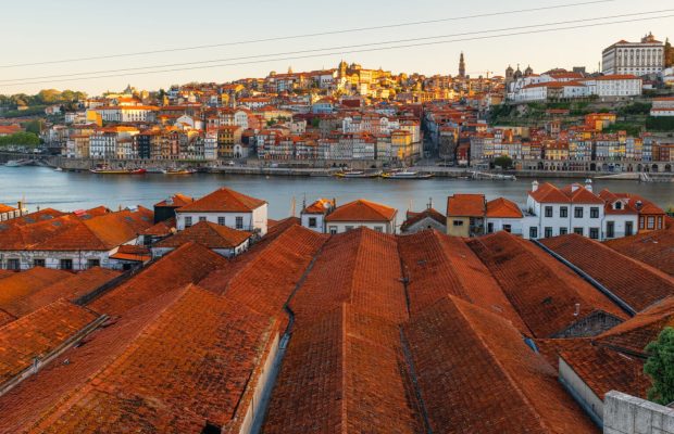 Porto, Portugal old town on the Douro River with orange rooftops of Vila Nova de Gaia buildings at sunrise. Medieval architecture of Oporto downtown. Travel destination